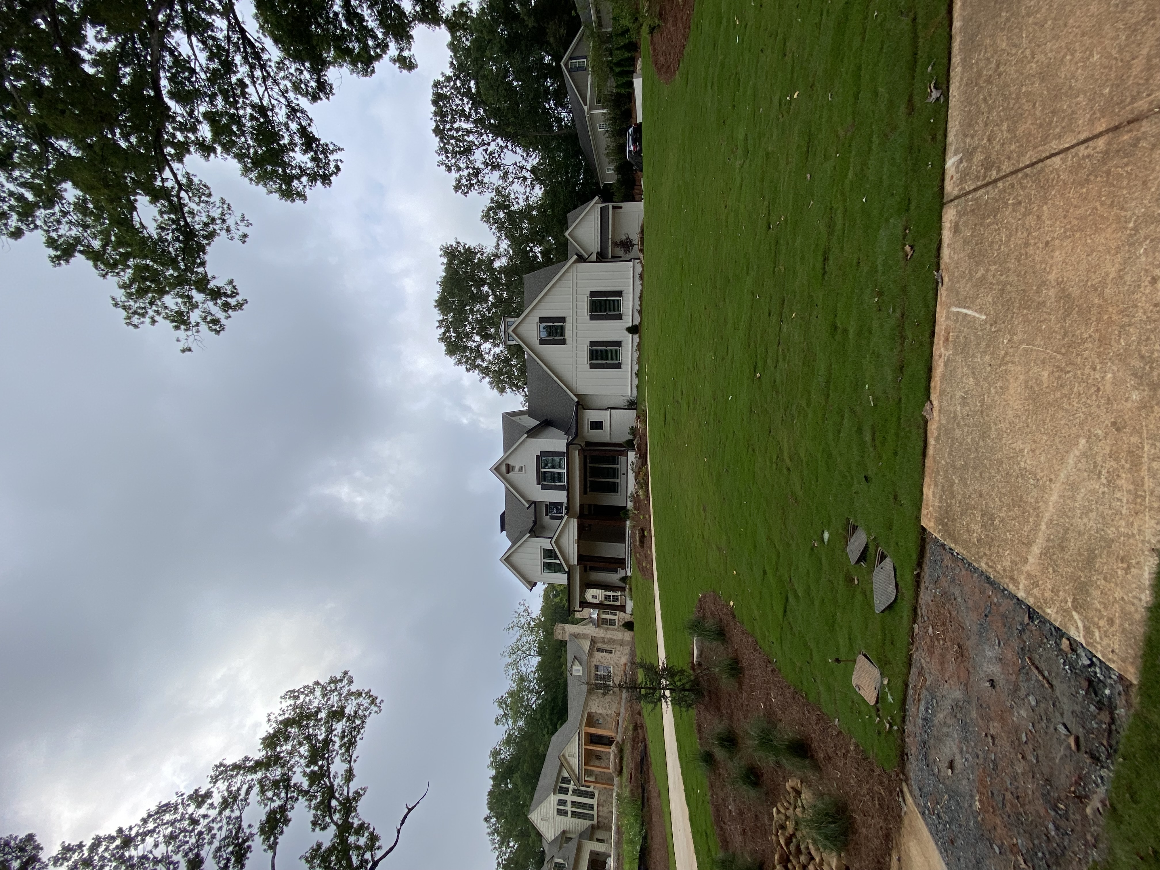 A house with a lawn and trees in the background on a sunny day